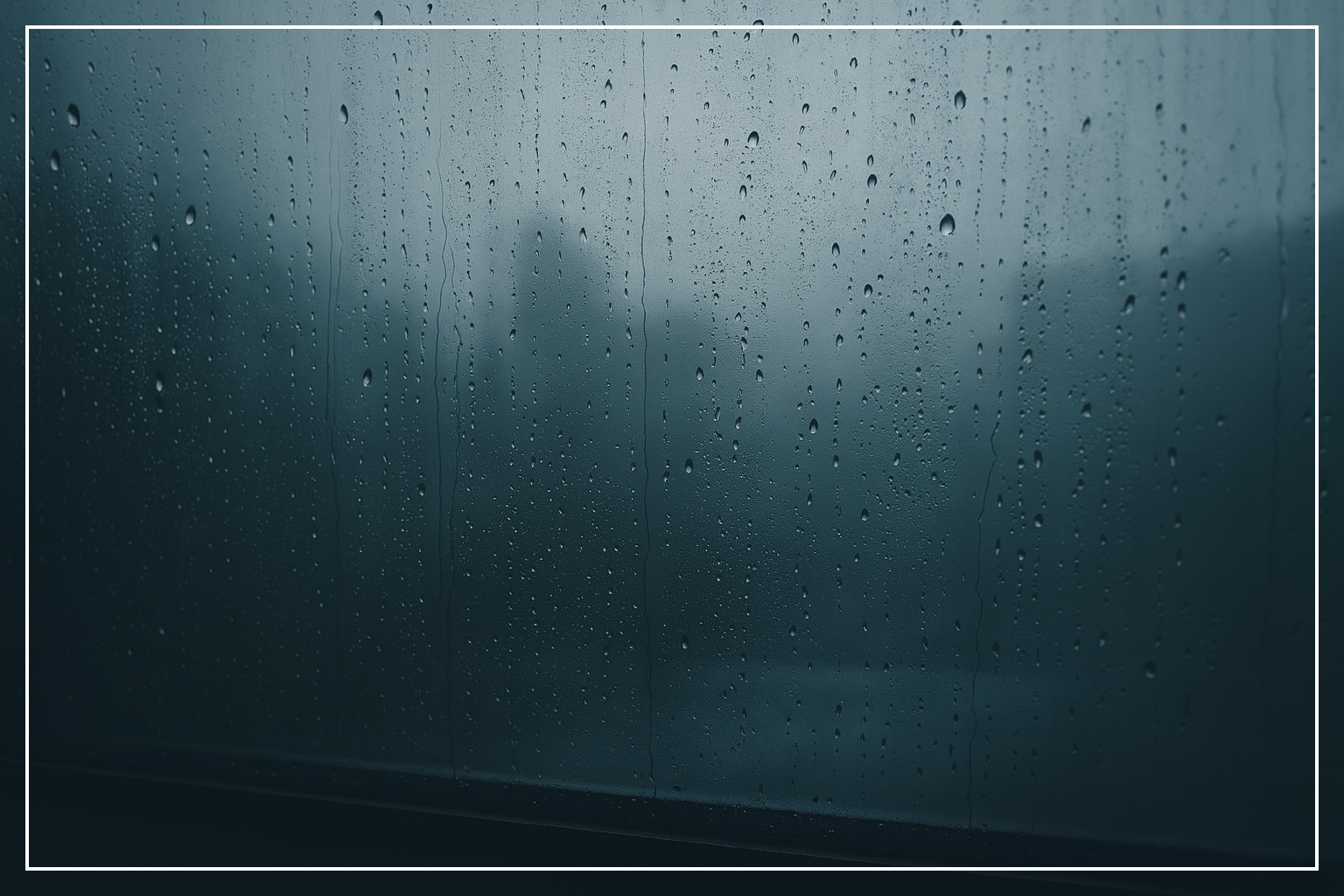 Großes verregnetes Fenster mit weichem, diffusem Licht. Wassertropfen laufen über die Scheibe, dahinter nur Konturen. Ruhige, nüchterne Atmosphäre.