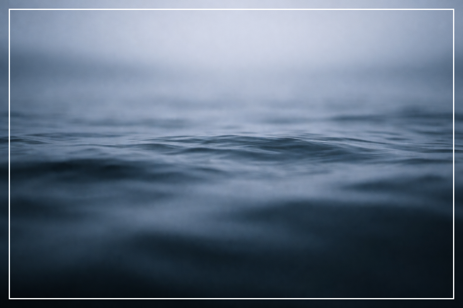Ruhige Wasseroberfläche in kaltem, gedämpftem Blau und Grau, leicht unscharf, ohne Menschen oder Objekte, Ausdruck von innerer Anspannung, Kontrolle und stillem Aushalten.
