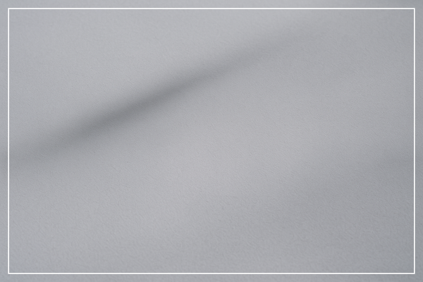 Graue minimalistische Oberfläche, weicher Schatten, kühle ruhige Textur, ohne Menschen.